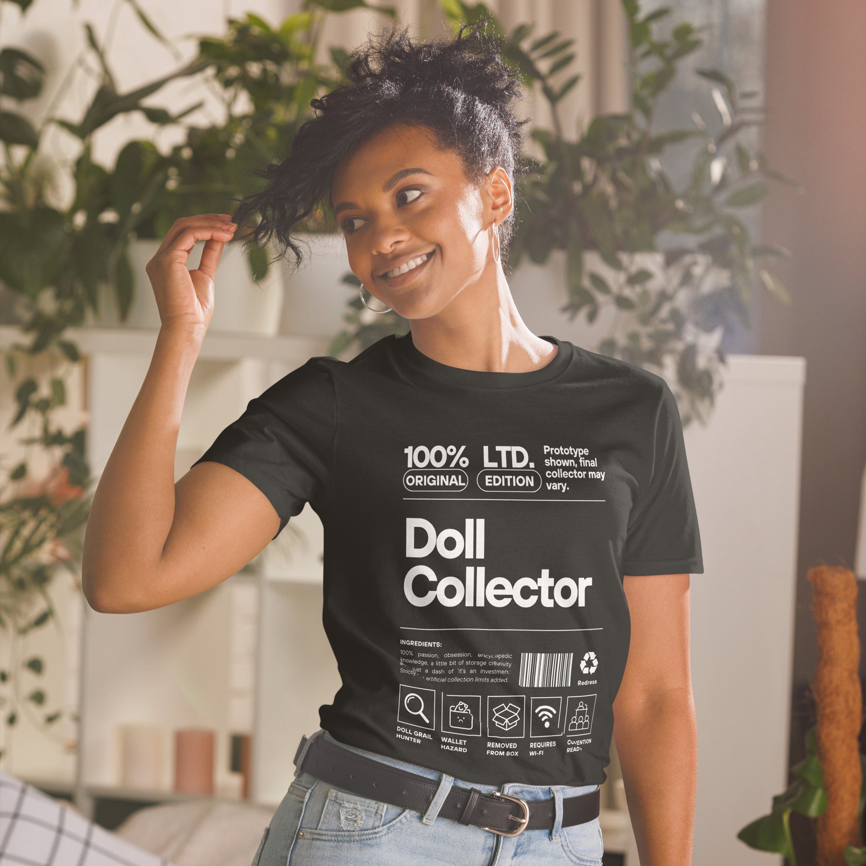 Person wearing a black t-shirt with 'Doll Collector' text in a casual setting