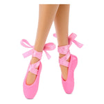 Pink ballet shoes with ribbons worn by a person on a white background